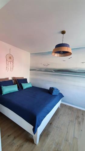赫爾的住宿－Przystań Hel Apartament，一间卧室配有一张带蓝色毯子的床