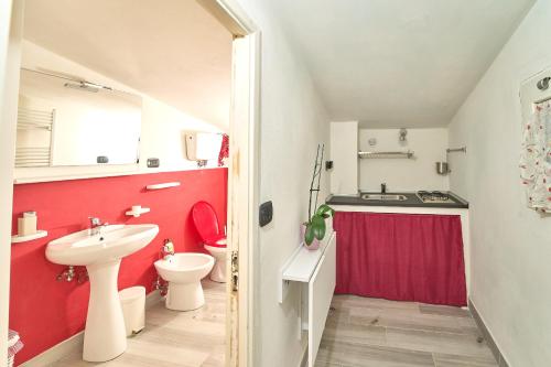 ein Badezimmer mit einem Waschbecken und einer roten Wand in der Unterkunft Casetta Bea in Celle sul Rigo