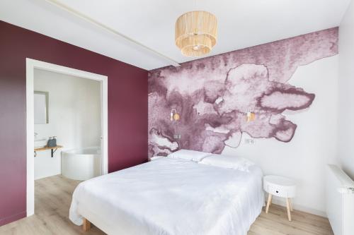 - une chambre avec un lit blanc et un mur violet dans l'établissement Chez Romain, à Solutré-Pouilly