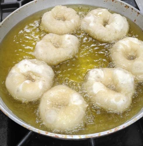 a pan of donuts being cooked in a sauce at vecchio frantoio in Spezzano Albanese