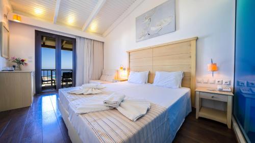 1 dormitorio con 1 cama grande y toallas. en Forest Park Hotel, en Rethymno