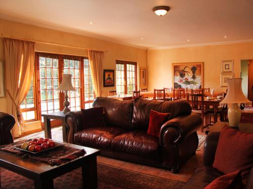 
a living room filled with furniture and a fire place at Fynbos Guest House Riversdale in Riversdale
