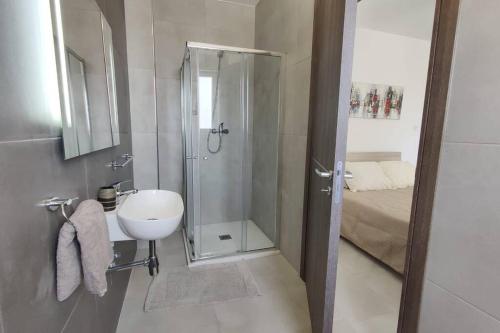 a small bathroom with a shower and a sink at Brand new 3 bedroom Apartment close to the sea in Il-Gżira