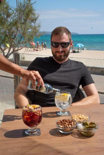 a man sitting at a table with a bottle of wine at Hotel Eden Palma Playa Adults Only in Can Pastilla