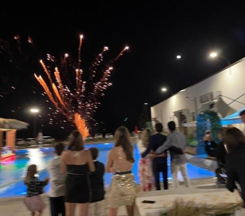 a group of people standing in front of a pool with fireworks at vecchio frantoio in Spezzano Albanese