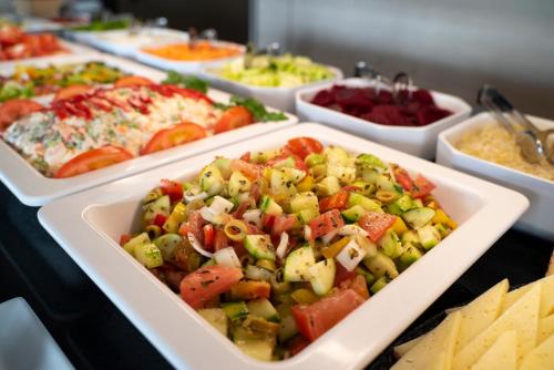 a buffet of different types of food in white dishes at Hotel Eden Palma Playa Adults Only in Can Pastilla
