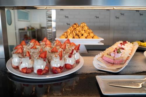 a buffet with strawberries and whipped cream and a sandwich at Hotel Eden Palma Playa Adults Only in Can Pastilla