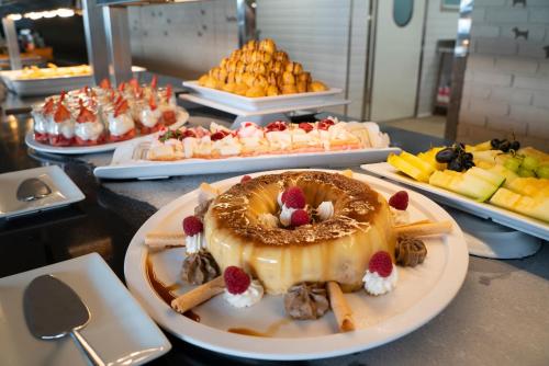 a table topped with a cake and other desserts at Hotel Eden Palma Playa Adults Only in Can Pastilla