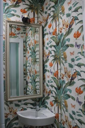 W łazience znajduje się umywalka i lustro. w obiekcie Apartamento de diseño en Malasaña junto a Gran Vía w Madrycie