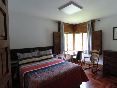1 dormitorio con 1 cama, mesa y sillas en El Chalet de la Poza - Río, barbacoa, Wifi, zona de trabajo, vistas., en Lebena