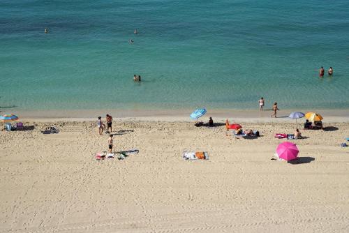 a group of people on a beach with the ocean at Hotel Eden Palma Playa Adults Only in Can Pastilla