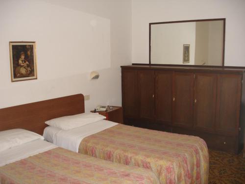 a hotel room with two beds and a mirror at Hotel La Rusticana in Giardini Naxos