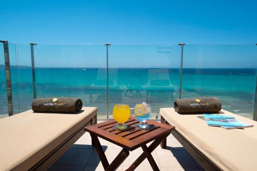 a table with a glass of orange juice on top of two tables at Hotel Playa Adults Only in Can Pastilla
