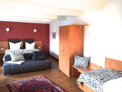 a bedroom with two beds and a couch in it at Hotel Garni Demmel & Cie in Rohrsheim