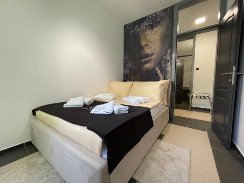 a bedroom with a bed with towels on it at Pollock Hotel, Ribarska Banja in Ribarska Banja