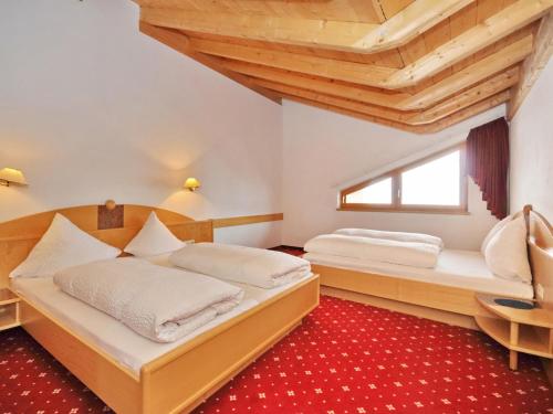 2 bedden in een kamer met houten plafonds bij Hotel Amadeus Micheluzzi in Serfaus