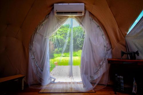 a door to a room with a window in a tent at That's life Glamping - Dolomite Experience in Dorgnan