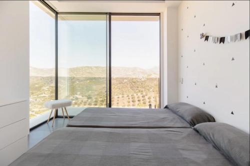 um quarto com uma cama grande e uma janela grande em Luxury Villa in Frigiliana - Villa Maui em Málaga