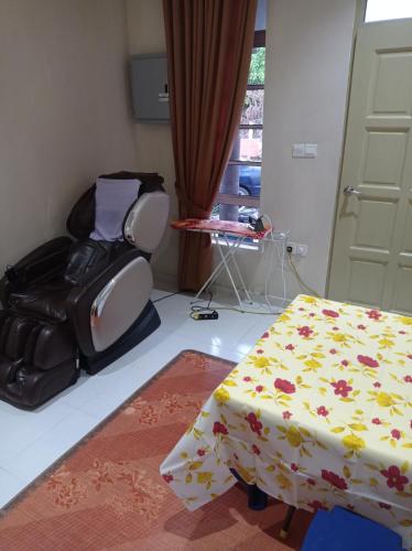 a room with a bed and a chair and a table at Desa Besut Inn in Kuala Besut