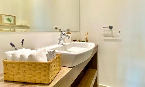 a bathroom with a sink and a basket of towels at Villa FORTE-Exclusive location with fantastic seaview & infinity pool - up to 8 Pax in Mimice