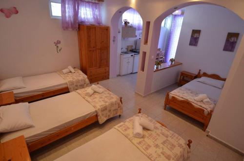 a small bedroom with two beds and a kitchen at Marianthi Studios Stegna in Archangelos
