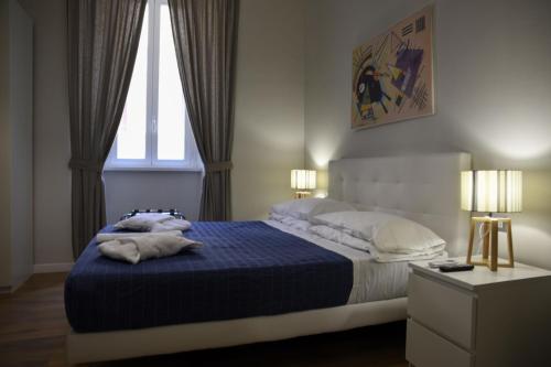 1 dormitorio con 1 cama con manta azul y 2 ventanas en The Castle Inside Rome, en Roma