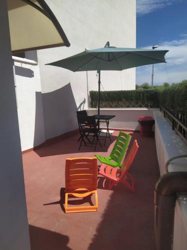 a patio with two chairs and a table and an umbrella at Scibetta's B&B in Taranto