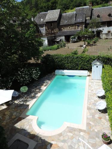 a swimming pool in the yard of a house at Auberge Saint Fleuret in Estaing