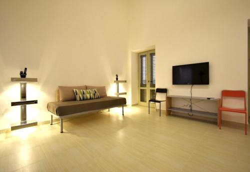 uma sala de estar com um sofá e uma televisão de ecrã plano em Casa Argento em Sciacca