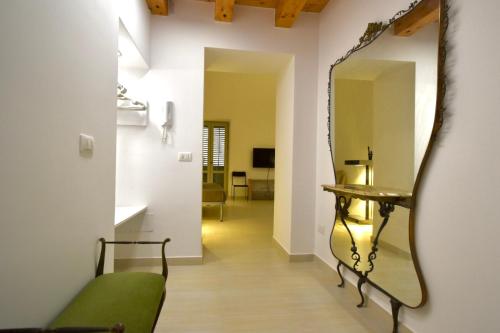 a hallway with a mirror and a green couch at Casa Argento in Sciacca