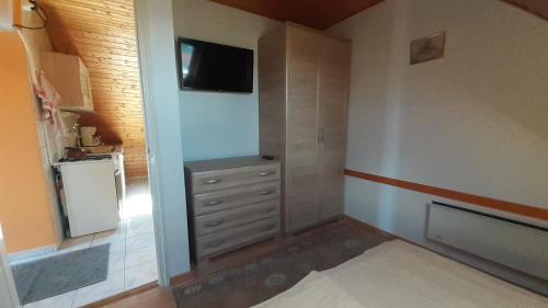 Habitación pequeña con vestidor y TV. en Pátri Apartmanház, en Keszthely