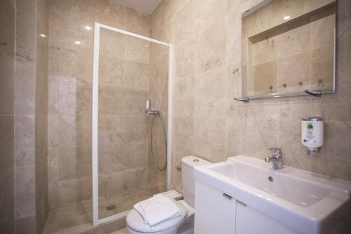 a bathroom with a shower and a toilet and a sink at Gran Central Suites in Madrid