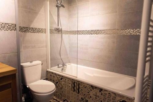 een badkamer met toilet en ligbad bij La mature in Fécamp