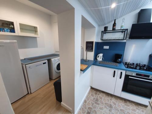 a kitchen with white cabinets and a washer and dryer at RACINES MARINES in Étaples