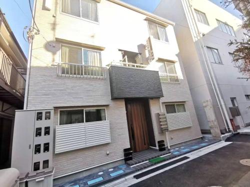a white building with a door and a balcony at YUYU-Wa-3 --Self Check-in -- Room Number & Password is in the following email in Tokyo