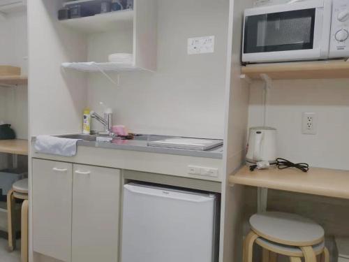 a small kitchen with a sink and a microwave at YUYU-Wa-3 --Self Check-in -- Room Number & Password is in the following email in Tokyo