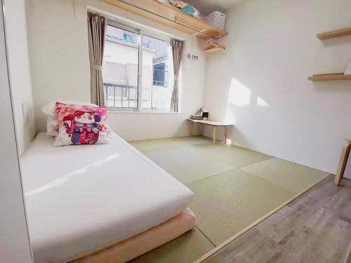 a white room with a bed and a window at YUYU-Wa-3 --Self Check-in -- Room Number & Password is in the following email in Tokyo