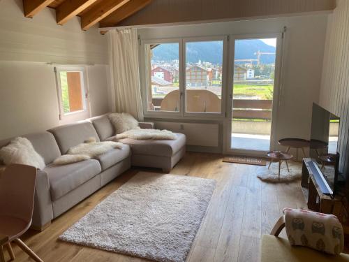sala de estar con sofá y ventana grande en Moderne Dachwohnung Nähe Zermatt mit Balkon, en Täsch