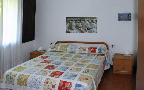 sypialnia z łóżkiem i zdjęciem na ścianie w obiekcie Villaggio Barbara w mieście Moniga
