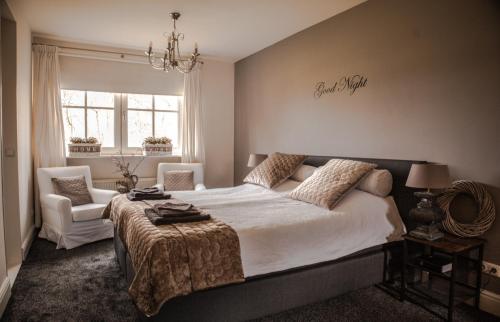 a bedroom with a large bed and two chairs at Studio Bed and Breakfast Zaans Moment in Assendelft