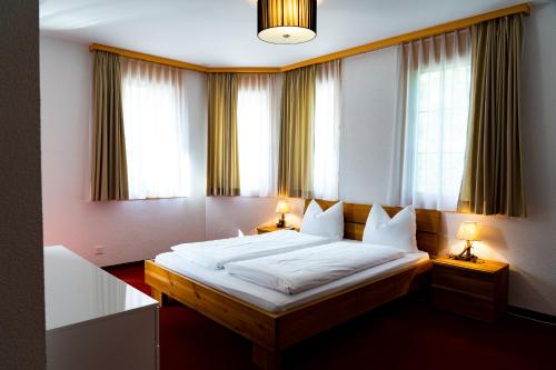 a bedroom with a bed with two lamps and two windows at Valletta in Arosa