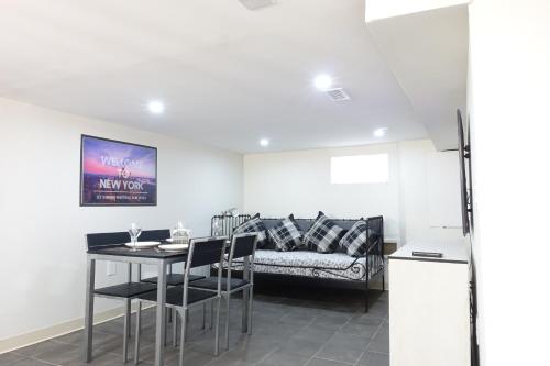 a dining room with a table and a couch at Best EWR Airport Apt-Hot Tub-Free Parking in Hillside