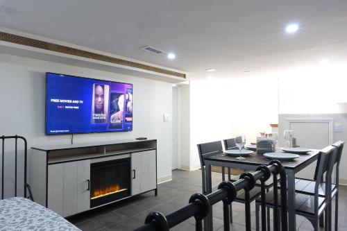 a living room with a tv and a table with chairs at Best EWR Airport Apt-Hot Tub-Free Parking in Hillside