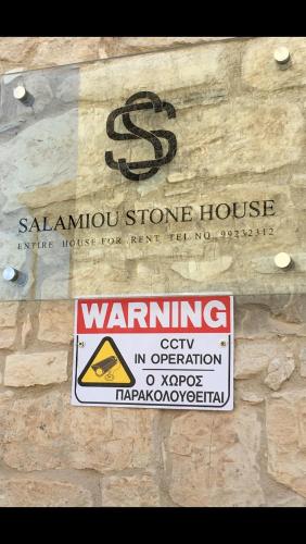 a sign for a saahu store house on a stone wall at Salamiou Stone House in Paphos City