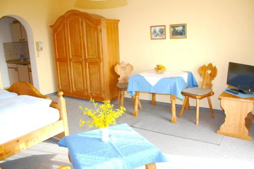 a room with a bedroom with a table and a tv at Appartementhaus Panny in Bad Füssing