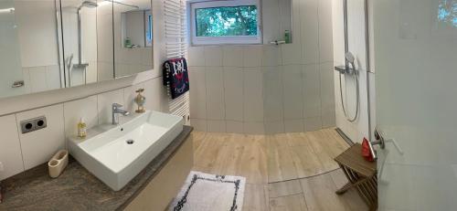 a bathroom with a sink and a shower at Maly´s Ferienwohnung in Sulzberg