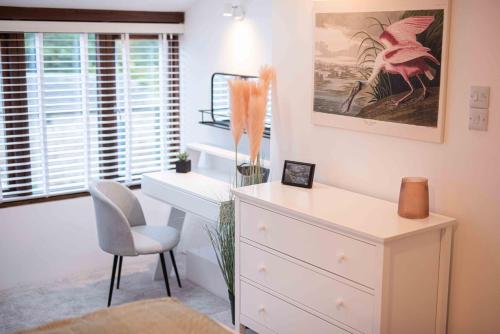 a bedroom with a dresser and a desk and a chair at Timber Hill - Parkfields in Haverfordwest
