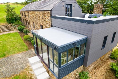 an exterior view of a house with a blue roof at Timber Hill - Parkfields in Haverfordwest