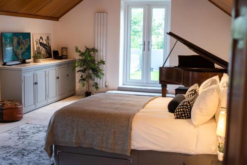 a bedroom with a large bed with a piano at Timber Hill - Parkfields in Haverfordwest