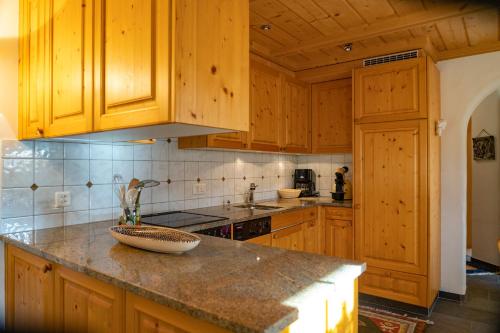 a kitchen with wooden cabinets and a counter top at Kulmwiesli in Arosa